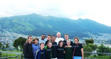 Students in front of a landscape of mountains and houses