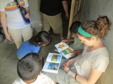 Student reading with children