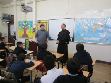 Priest and student teaching class of children