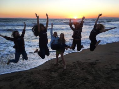 Students leaping on a beach in LA