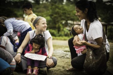 Two students holding children