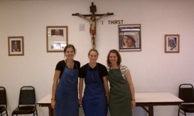 Students standing in front of a crucifix
