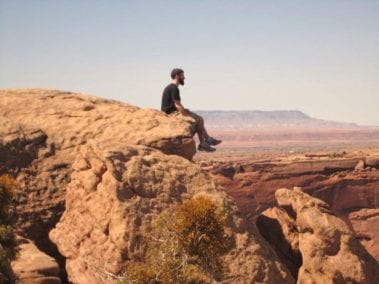 Student sitting on the edge of a cliff