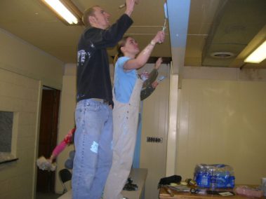 Students painting the inside of a house
